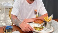 Lionel Messi juga senang memanfaatkan waktu kosongnya untuk berlibur. Ketika pergi ke Ibiza, seporsi burger dan kentang goreng jadi kudapan yang dipesan saat melipir ke sebuah restoran. Foto: Instagram/leomessi