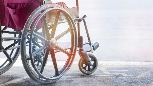 close up view of empty wheelchair with Pavement handicap symbol