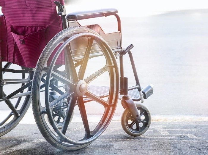 close up view of empty wheelchair with Pavement handicap symbol