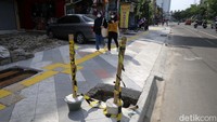 Ada banyak lubang air di tengah trotoar yang belum ditutup.
