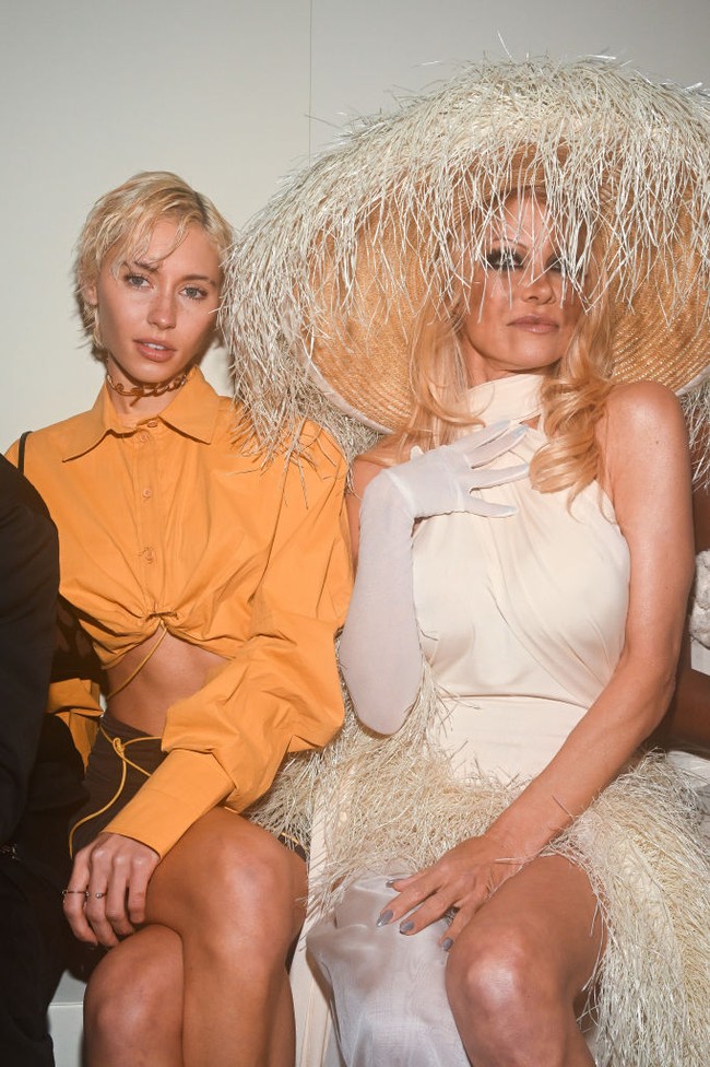 Aksesori andalannya tak kalah mencuri perhatian. Pamela Anderson tampak memakai topi anyaman yang penuh jerami. Saking lebarnya topi tersebut, tamu lain yang duduk di sebelah Pamela sampai harus memiringkan kepala. (Foto: Getty Images)