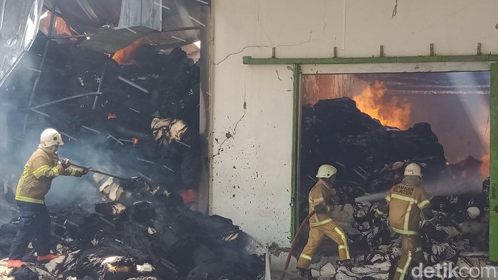 Pemadam kebakaran Satpol PP Pemkab Klaten berupaya memadamkan api di gudang pabrik kain di PT Kusumananda Putra, Klaten, Rabu (14/12/2022).
