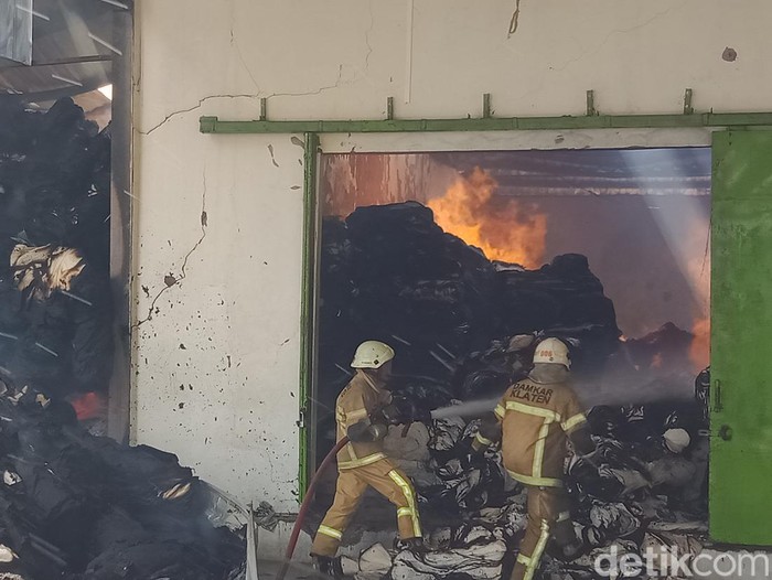 Pemadam kebakaran Satpol PP Pemkab Klaten berupaya memadamkan api di gudang pabrik kain di PT Kusumananda Putra, Klaten, Rabu (14/12/2022).