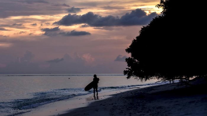 Wisatawan asing membawa papan surfing di pinggiran pantai wisata Gili Trawangan, Kecamatan Pemenang, Tanjung, Lombok Utara, NTB, Rabu (14/12/2022). Menjelang libur Natal dan Tahun Baru 2023 wisatawan asing mulai ramai mengunjungi destinasi wisata Gili Trawangan.ANTARA FOTO/Ahmad Subaidi/aww.