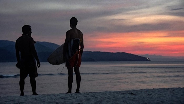 Wisatawan asing membawa papan surfing di pinggiran pantai wisata Gili Trawangan, Kecamatan Pemenang, Tanjung, Lombok Utara, NTB, Rabu (14/12/2022). Menjelang libur Natal dan Tahun Baru 2023 wisatawan asing mulai ramai mengunjungi destinasi wisata Gili Trawangan.ANTARA FOTO/Ahmad Subaidi/aww.