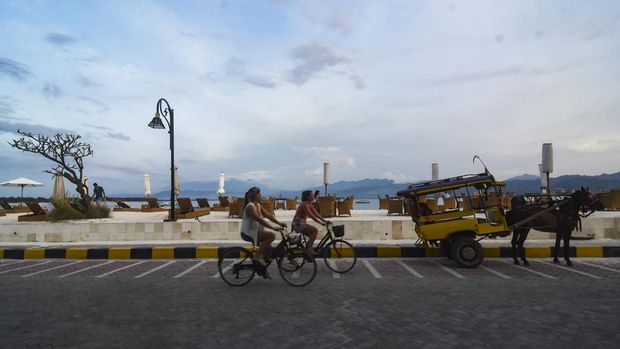 Wisatawan asing menaiki sepeda di pinggiran pantai wisata Gili Trawangan, Kecamatan Pemenang, Tanjung, Lombok Utara, NTB, Rabu (14/12/2022). Menjelang libur Natal dan Tahun Baru 2023 wisatawan asing mulai ramai mengunjungi destinasi wisata Gili Trawangan.ANTARA FOTO/Ahmad Subaidi/aww.