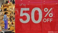 Pengunjung pusat perbelanjaan melintas di depan tanda diskon atau potongan harga di Jakarta Selatan, Rabu (14/12/2022).