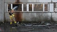 Petugas pemadam kebakaran mencoba memadamkan api di salah satu gedung pemukiman. Foto: Anadolu Agency via Getty Images/Anadolu Agency
