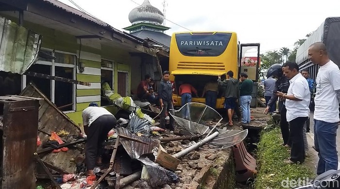 Bus pariwisata menabrak teras rumah warga di Padang Panjang. (Foto: Jeka Kampai)