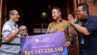 Direktur PT AXA Mandiri Financial Services (AXA Mandiri) Rudi Nugraha bersama Vice President Bank Mandiri Ananditho J. Prakoso secara simbolis menyerahkan pembayaran klaim sebesar Rp 1.14 M kepada Bibit Andriani Susilowati yang didampingi suaminya Yudi Darmawan, ahli waris dan juga orang tua almarhum Beni Sucahyo Darmawan, nasabah Asuransi Mandiri Perlindungan Sejahtera dari AXA Mandiri sejak tahun 2020, di Nganjuk, Jawa Timur, Kamis (15/12/2022).