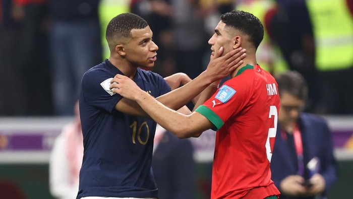 AL KHOR, QATAR - DECEMBER 14: Kylian Mbappe of France embraces fellow PSG team mate Achraf Hakimi of Morocco  during the FIFA World Cup Qatar 2022 semi final match between France and Morocco at Al Bayt Stadium on December 14, 2022 in Al Khor, Qatar. (Photo by James Williamson - AMA/Getty Images)