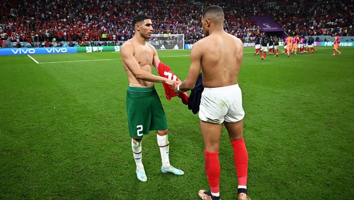 Momen Dua Sabahat Mbappe-Hakimi Tukeran Jersey AL KHOR, QATAR - DECEMBER 14: Achraf Hakimi of Morocco swaps shirts with Kylian Mbappe of France after the FIFA World Cup Qatar 2022 semi final match between France and Morocco at Al Bayt Stadium on December 14, 2022 in Al Khor, Qatar. (Photo by Michael Regan - FIFA/FIFA via Getty Images)