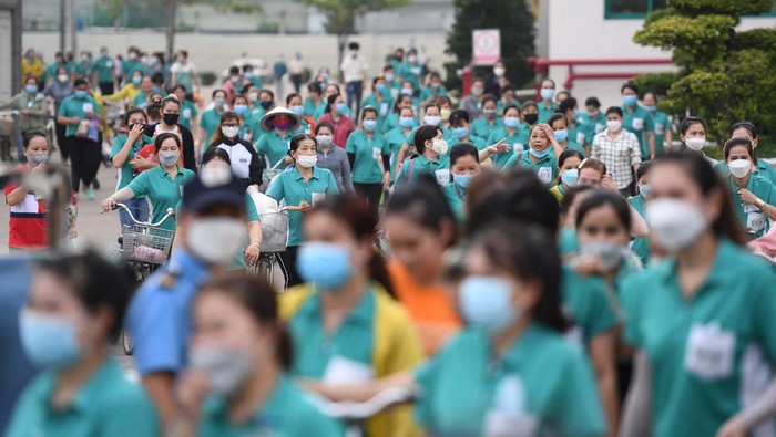 This picture taken on November 30, 2022 shows workers leaving their workplace at Taiwanese Ty Hung factory in Ho Chi Minh City. - Almost half a million workers have been forced to work fewer hours as orders fall in the Southeast Asian country, one of the world's largest exporters of clothing, footwear and furniture. The cost-of-living crisis in Europe and the United States -- major markets for Vietnamese-produced goods -- has seen the buying power of Western shoppers take a dive. - To go with AFP Focus 'Vietnam-Economy-Labour' by Tran Thi Minh Ha (Photo by Nhac NGUYEN / AFP) / To go with AFP Focus 'Vietnam-Economy-Labour' by Tran Thi Minh Ha (Photo by NHAC NGUYEN/AFP via Getty Images)