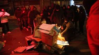 Massa membakar kardus di tengah jalan.