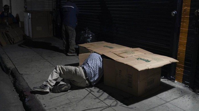 Potret Los Angeles yang Dipenuhi Gelandangan David Hernandez, a 62-year-old homeless man, crawls into his bed made with cardboard boxes in Los Angeles, late Wednesday, Dec. 14, 2022. Los Angeles Mayor Karen Bass declared a state of emergency Monday to grapple with the city's out-of-control homeless crisis, bidding to move swiftly to get thousands of unhoused people off her city's streets. (AP Photo/Jae C. Hong)