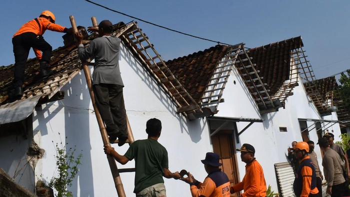 Rumah Warga yang Rusak Akibat Puting Beliung di Madiun Mulai Diperbaiki petugas gabungan yang terdiri prajurit TNI, polisi, petugas Badan Penanggulangan Bencana Daerah (BPBD), relawan dan warga melakukan kerja bakti merapikan rumah warga yang rusak akibat puting beliung di Sidomulyo, Kabupaten Madiun, Jawa Timur, Kamis (15/12/2022). Puting beliung yang terjadi Rabu (14/12) petang mengakibatkan lima rumah warga rusak, puluhan pohon tumbang dan dua orang warga mengalami luka.