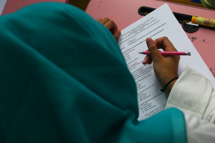 Seorang murid mengerjakan soal Pendidikan Pancasila dan Kewarganegaraan di Sanggar Bimbingan Kepong, Kuala Lumpur,  Malaysia, Rabu (14/12/2022). Sejumlah sanggar bimbingan di Kuala Lumpur akan serempak melaksanakan ujian atau penilaian akhir semester Tahun Pelajaran 2022-2023 untuk murid-muridnya pekan depan. ANTARA FOTO/Virna Puspa Setyorini/aww.