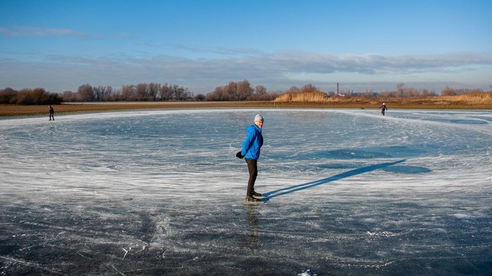 NIJMEGEN, NETHERLANDS - 2022/12/15: An old man is seen skating on natural ice. After three days of sub-zero temperatures (around -7 degrees Celsius during the night), the water of some lakes froze. Some skaters took the chance despite the low levels of water, that provided a small part of ice surface large enough to skate, on the 'Oude Waal' lake. (Photo by Ana Fernandez/SOPA Images/LightRocket via Getty Images)