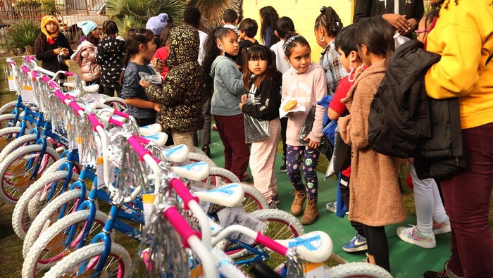 Bahagianya Anak-anak di AS Dapat Kado Sepeda Jelang Natal WATTS, CA - DECEMBER 15, 2022 - - Aiden Abiy, 8, from Compton Avenue Elementary School, walks away with his new bike at the Parents of Watts Working With Youth & Adults, Inc., annual Christmas bike and toy giveaway at Hatten Family Childcare in Watts on December 15, 2022. Sweet'' Alice Harris, founder of Parents of Watts Working With Youth & Adults, Inc., oversaw the event where some 400 students from 10 schools in Watts received new 20-inch Huffy bicycles, helmets, toys/gifts and lunch. (Genaro Molina / Los Angeles Times via Getty Images)