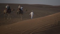 Wisatawan menaiki Unta saat berwisata gurun pasir di Dubai, Uni Emirat Arab, Kamis (15/12/2022).