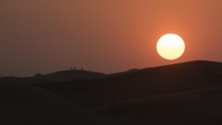 Wisatawan menyaksikan matahari tenggelam saat berwisata gurun pasir di Dubai, Uni Emirat Arab.