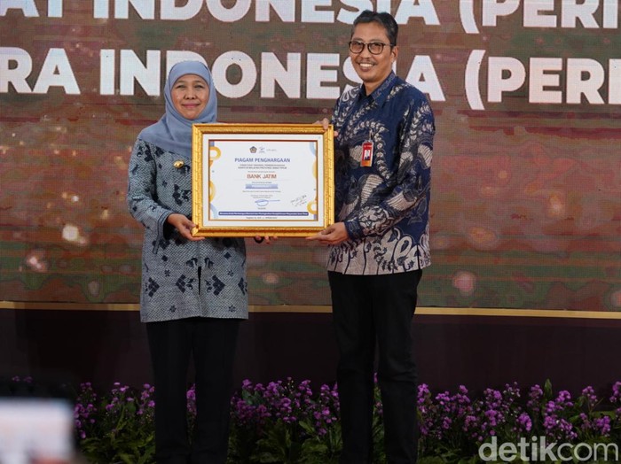 Dirut Bank Jatim Busrul Iman saat menerima piagam penghargaan dari Gubernur Jatim Khofifah