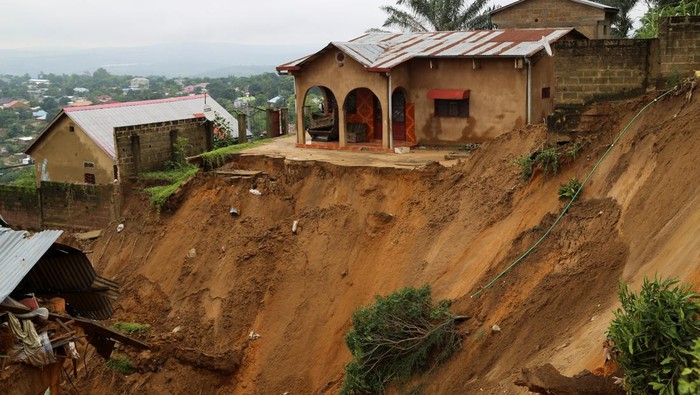 A house stands next to a seriously damaged road after heavy rains caused floods and landslides, on the outskirts of Kinshasa, Democratic Republic of Congo December 14,2022. REUTERS/Justin Makangara
