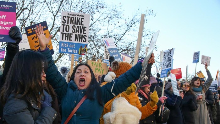 LONDON, UNITED KINGDOM - 2022/12/15: NHS nurses hold placards expressing their opinion during a protest outside St. Thomas Hospital in central London on day one of the two strikes taking place this month. Thousands of nurses across the country are striking in a dispute over pay and working conditions, making it the largest strike in NHS history. Due to the industrial action, number of routine operations have been cancelled. (Photo by Steve Taylor/SOPA Images/LightRocket via Getty Images)