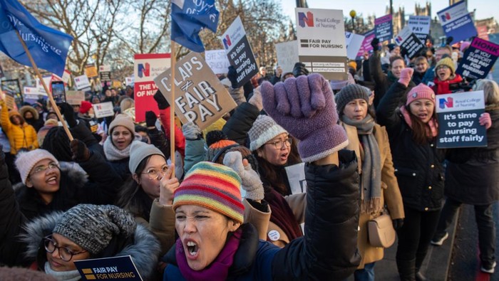 Nurses stand behind a banner at an official picket line outside St Thomas' hospital on 15 December 2022 in London, United Kingdom. Nurses in England, Wales and Northern Ireland from the Royal College of Nursing (RCN) have taken part in the first of two 12-hour strikes over pay and working conditions, the first such mass walkout of nurses in a century. (photo by Mark Kerrison/In Pictures via Getty Images)