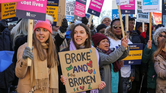 Nurses stand behind a banner at an official picket line outside St Thomas' hospital on 15 December 2022 in London, United Kingdom. Nurses in England, Wales and Northern Ireland from the Royal College of Nursing (RCN) have taken part in the first of two 12-hour strikes over pay and working conditions, the first such mass walkout of nurses in a century. (photo by Mark Kerrison/In Pictures via Getty Images)