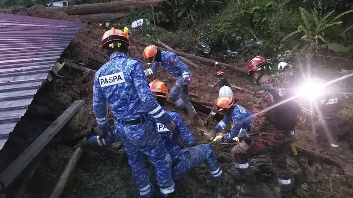 In this photo provided by Civil Defense Department, Civil Defense personnel search for survivors buried after a landslide hit a campsite in Batang Kali, Malaysia, Friday, Dec. 16, 2022. A landslide hit the campsite outside Kuala Lumpur early Friday, Malaysias fire department said. (Malaysia Civil Defence via AP )