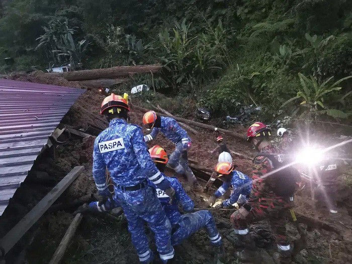 In this photo provided by Civil Defense Department, Civil Defense personnel search for survivors buried after a landslide hit a campsite in Batang Kali, Malaysia, Friday, Dec. 16, 2022. A landslide hit the campsite outside Kuala Lumpur early Friday, Malaysias fire department said. (Malaysia Civil Defence via AP )