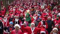 Para pelari berpakaian Sinterklas mengikuti Natal Corrida Race di jalanan Issy Les Moulineaux, di luar Paris, Minggu (11/12/2022). Foto: AP/Francois Mori