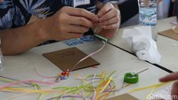 Dengan semangat mereka merangkai lembaran-lembaran pita menjadi sebuah karya seni yang nantinya akan bernilai jual.