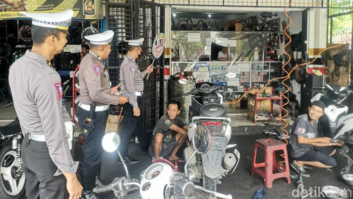 Sejumlah personel Satlantas Polres Bojonegoro sosialisasikan larangan knalpot brong ke toko dan bengkel variasi motor
