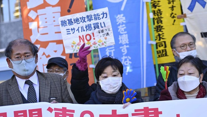 Demonstrators hold a protest near government offices in the Nagatacho area of Tokyo on December 16, 2022, as the prime minister's cabinet looks to approve a defence security package. - Japan's government was poised to approve a major defence policy overhaul on December 16, including a significant spending hike, as it warns China poses the 