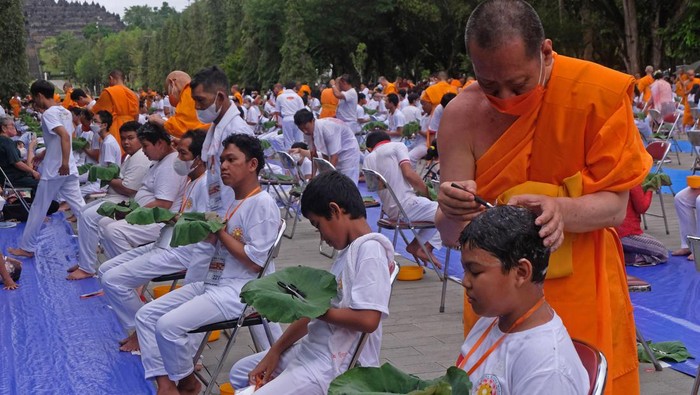 Bikkhu mencukur rambut calon Samanera (bikkhu Kecil) saat ritual potong rambut dalam rangkaian upacara Pabbajja Samanera di marga utama kompleks Taman Wisata Candi (TWC) Borobudur, Magelang, Jawa Tengah, Jumat (16/12/2022). Kegiatan yang diikuti oleh ratusan peserta tersebut merupakan bentuk pengenalan kehidupan monastik atau kerahiban, sekaligus pelatihan moral dan spiritual dalam Agama Buddha. ANTARA FOTO/Anis Efizudin/foc.