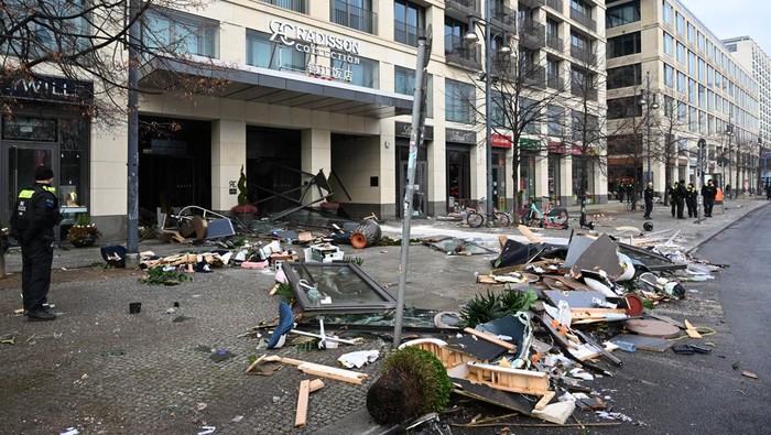 16 December 2022, Berlin: A police officer stands outside the entrance to Sea Life at the Radisson Hotel in front of the wreckage. In the morning, the aquarium in the hotel lobby had broken apart. Photo: Soeren Stache/dpa (Photo by Soeren Stache/picture alliance via Getty Images)