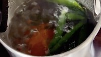 Agar teksturnya tak terlalu keras, Via merebus lebih dahulu 15 cabe ijo dan 1 buah tomat di kamar hotel.