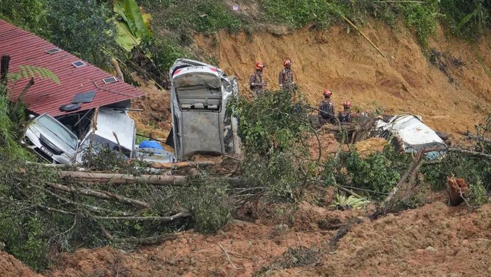 Rescue teams continue the search for victims caught in a landslide, Saturday, Dec. 17, 2022, in Batang Kali, Malaysia. A landslide Friday, Dec. 16, 2022, at a tourist campground in Malaysia left more than a dozen of people dead and authorities said a dozen of others were feared buried at the site on an organic farm outside the capital of Kuala Lumpur. (AP Photo Vincent Thian)