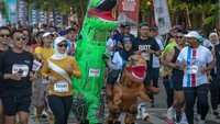 Saat mengikuti lomba lari, tampak dua orang peserta mengenakan kostum dinosaurus yang menjadi pusat perhatian para peserta lain. Kegiatan ini diikuti oleh 2100 peserta dari berbagai daerah di Indonesia.