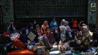 Beberapa pengungsi menggelar tikar di dekat lokasi kejadian sembari melihat rumahnya yang sudah hangus terbakar.