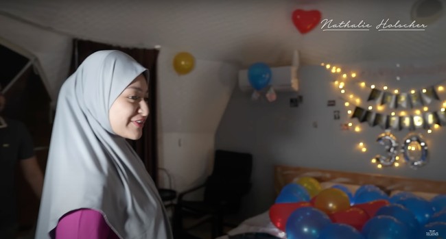 Kamar tersebut tampak sudah dipenuhi dengan balon berwarna-warni dan tulisan Happy Birthday untuk Nathalie Holscher. Ekspresi bahagia pun terlihat jelas di wajah Nathalie Holscher. Foto: YouTube/Nathalie Holscher