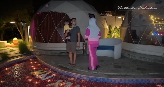 Di luar kamar tersebut rupanya Faris juga telah menyiapkan kejutan lain untuk Nathalie. Ia telah mendekorasi kolam renangnya dengan begitu banyak kelopak bunga dan membentuk tulisan ILY NH spesial untuk Nathalie dari kelopak bunga tersebut. Foto: YouTube/Nathalie Holscher