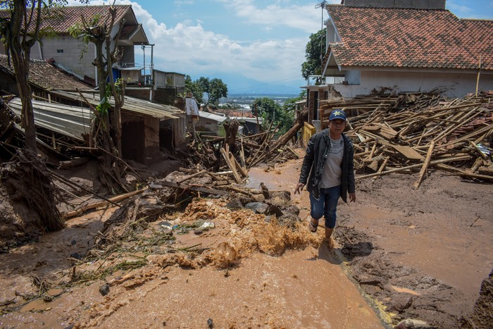 Warga membersihkan puing akibat banjir bandang di Sawahdadap, Cimanggung, Kabupaten Sumedang, Jawa Barat, Minggu (18/12/2022). Terjangan banjir bandang akibat intensitas hujan yang tinggi pada Sabtu (17/12/2022) petang tersebut mengakibatkan sejumlah rumah rusak dan ratusan warga mengungsi serta dua orang meninggal dunia. ANTARA FOTO/Ahmad Fauzan/rai/wsj.