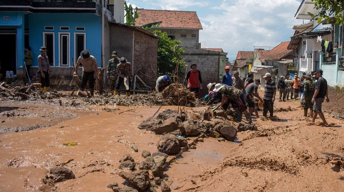 Penampakan Sisa-sisa Banjir Bandang yang Melanda Sumedang Warga membersihkan puing akibat banjir bandang di Sawahdadap, Cimanggung, Kabupaten Sumedang, Jawa Barat, Minggu (18/12/2022). Terjangan banjir bandang akibat intensitas hujan yang tinggi pada Sabtu (17/12/2022) petang tersebut mengakibatkan sejumlah rumah rusak dan ratusan warga mengungsi serta dua orang meninggal dunia. ANTARA FOTO/Ahmad Fauzan/rai/wsj.