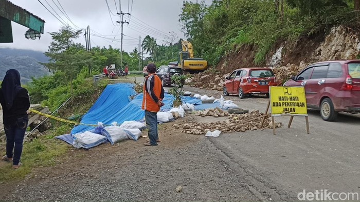 Suasana Jalan Trans Sulawesi ambles. Lalu lintas terganggu dan 1 rumah ambruk.