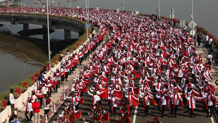 Sejumlah pelajar menari Remo saat Tari Remo Massal di Jembatan Suroboyo, Surabaya, Jawa Timur, Minggu (18/12/2022). Tari Remo Massal yang diikuti 65.946 pelajar dan digelar di sejumlah lokasi di Surabaya itu memecahkan rekor  Museum Rekor-Dunia Indonesia (MURI) Tari Remo oleh Pelajar secara Serentak di Situs Sejarah dan Jembatan Terbanyak. ANTARA FOTO/Didik Suhartono/foc.