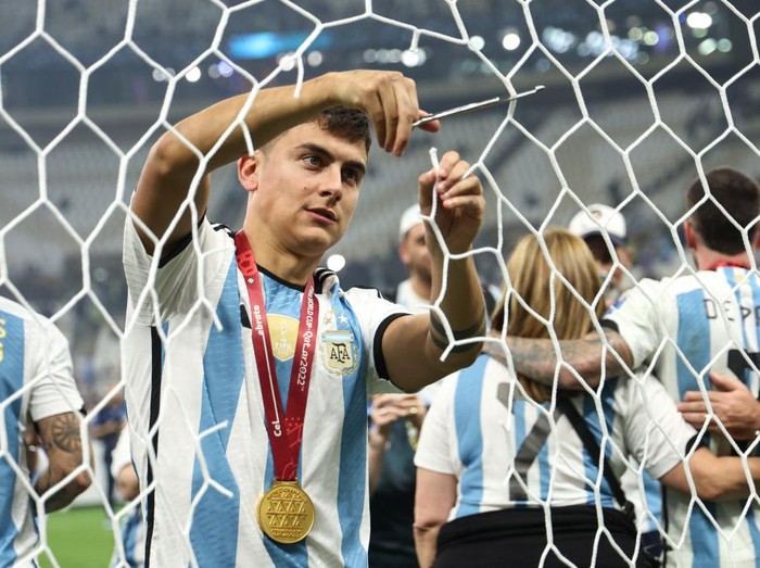 LUSAIL CITY, QATAR - DECEMBER 18: Paulo Dybala of Argentina cuts a piece of the goal net after winning the FIFA World Cup during the FIFA World Cup Qatar 2022 Final match between Argentina and France at Lusail Stadium on December 18, 2022 in Lusail City, Qatar. (Photo by Matthew Ashton - AMA/Getty Images)