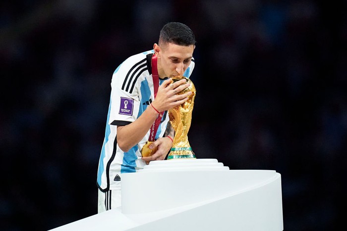 LUSAIL CITY, QATAR - DECEMBER 18: Angel Di Maria of Argentina kisses the FIFA World Cup Winners Trophy at the award ceremony following the FIFA World Cup Qatar 2022 Final match between Argentina and France at Lusail Stadium on December 18, 2022 in Lusail City, Qatar. (Photo by Quality Sport Images/Getty Images)